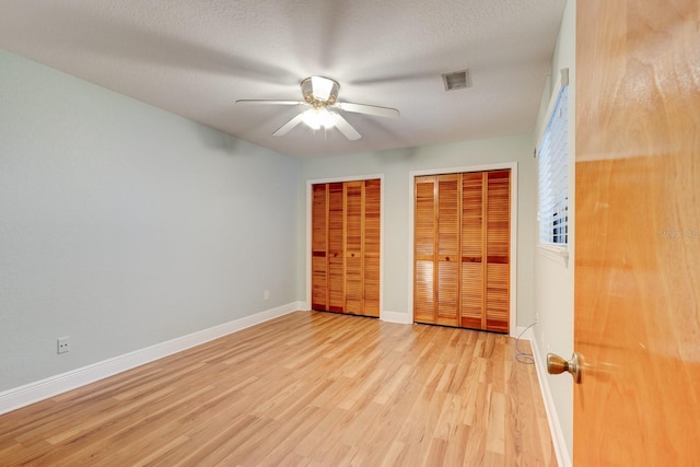 488 Shorewood Ln, New Smyrna Beach, FL 32168 - unfurnished bedroom with two closets, light wood-style flooring, baseboards, and ceiling fan