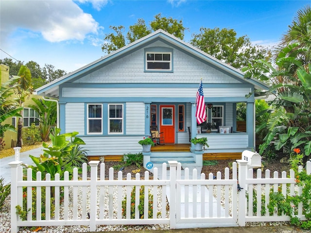 216 Murray St, New Smyrna Beach, FL 32168 - bungalow-style home featuring a porch, a fenced front yard, and a gate