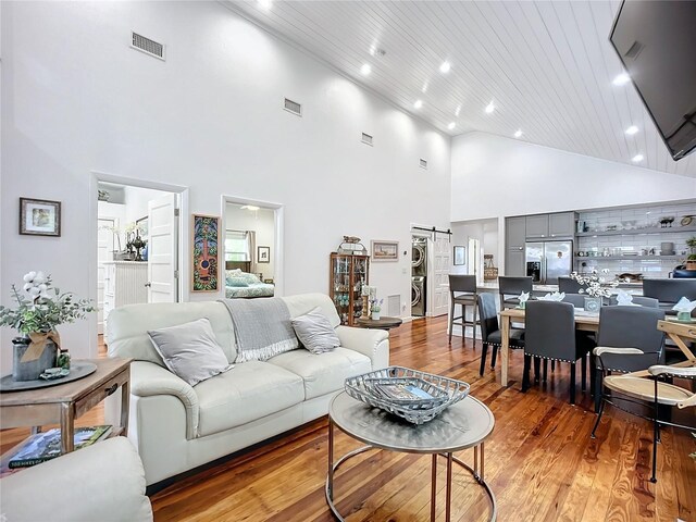 216 Murray St, New Smyrna Beach, FL 32168 - living room with high vaulted ceiling, light wood-style floors, recessed lighting, wood ceiling, and a barn door
