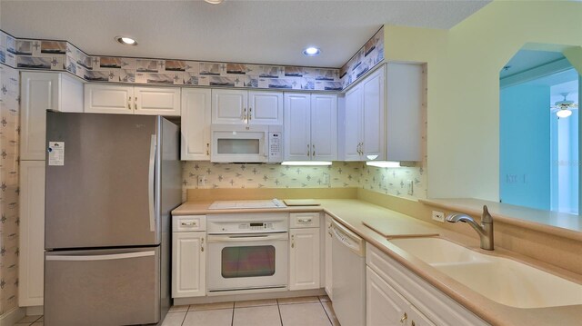4620 Riverwalk Village Ct Unit 7306, Ponce Inlet, FL 32127 - kitchen with white appliances, a sink, light tile patterned flooring, white cabinets, and light countertops