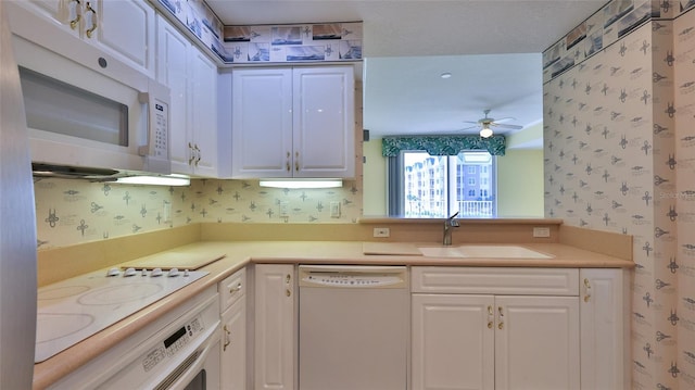 4620 Riverwalk Village Ct Unit 7306, Ponce Inlet, FL 32127 - kitchen with white appliances, wallpapered walls, a sink, white cabinets, and light countertops