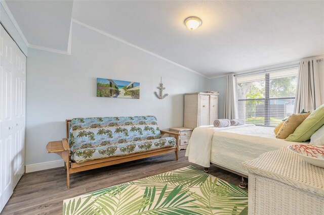 76 Heather Point Ct, New Smyrna Beach, FL 32169 - bedroom featuring vaulted ceiling, wood finished floors, a closet, baseboards, and ornamental molding