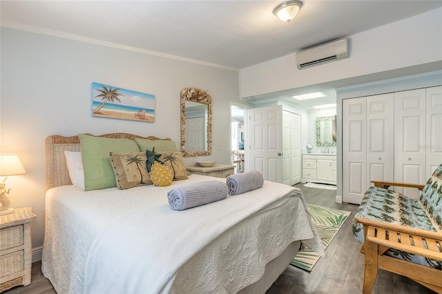 76 Heather Point Ct, New Smyrna Beach, FL 32169 - bedroom featuring a wall unit AC, wood finished floors, crown molding, ensuite bath, and two closets