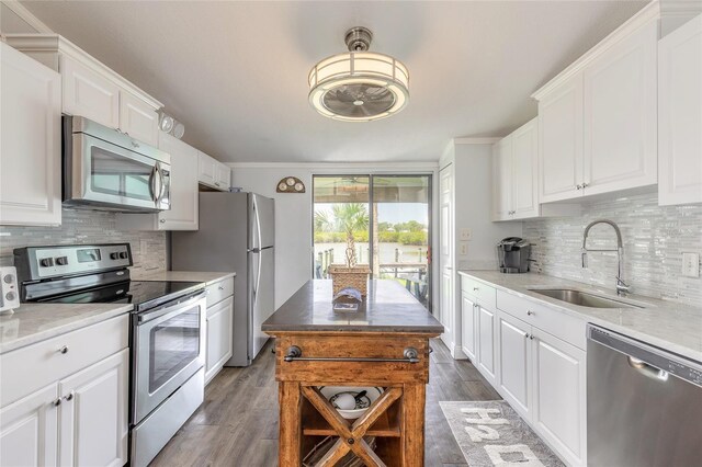 76 Heather Point Ct, New Smyrna Beach, FL 32169 - kitchen with appliances with stainless steel finishes, a sink, dark wood finished floors, and white cabinetry