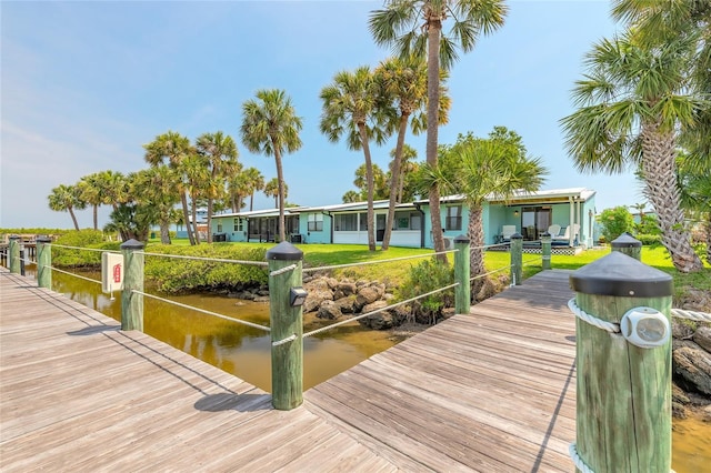 76 Heather Point Ct, New Smyrna Beach, FL 32169 - dock area featuring a water view and a lawn