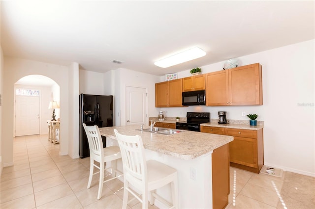 2818 Taton Trce, New Smyrna Beach, FL 32168 - kitchen with black appliances, a sink, light tile patterned floors, arched walkways, and light countertops