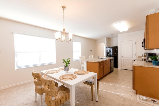 2818 Taton Trce, New Smyrna Beach, FL 32168 - dining area featuring a chandelier, arched walkways, light tile patterned floors, and light colored carpet