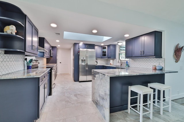 475 Spruceview Dr, Port Orange, FL 32127 - kitchen with stainless steel appliances, a sink, a peninsula, light stone countertops, and decorative backsplash