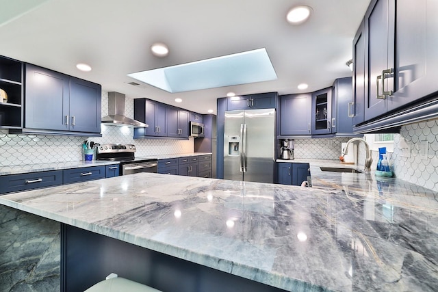 475 Spruceview Dr, Port Orange, FL 32127 - kitchen with appliances with stainless steel finishes, wall chimney exhaust hood, a peninsula, a sink, and a skylight