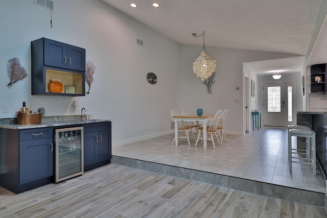 475 Spruceview Dr, Port Orange, FL 32127 - dining room with beverage cooler, lofted ceiling, light wood-style floors, bar area, and recessed lighting