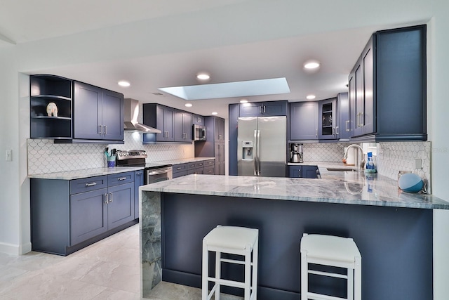 475 Spruceview Dr, Port Orange, FL 32127 - kitchen with appliances with stainless steel finishes, wall chimney range hood, a peninsula, light stone countertops, and tasteful backsplash