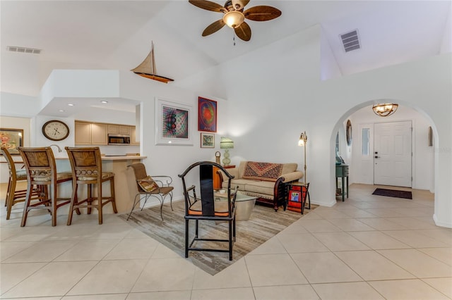484 Sweet Bay Ave, New Smyrna Beach, FL 32168 - living area with arched walkways, high vaulted ceiling, light tile patterned floors, ceiling fan, and baseboards