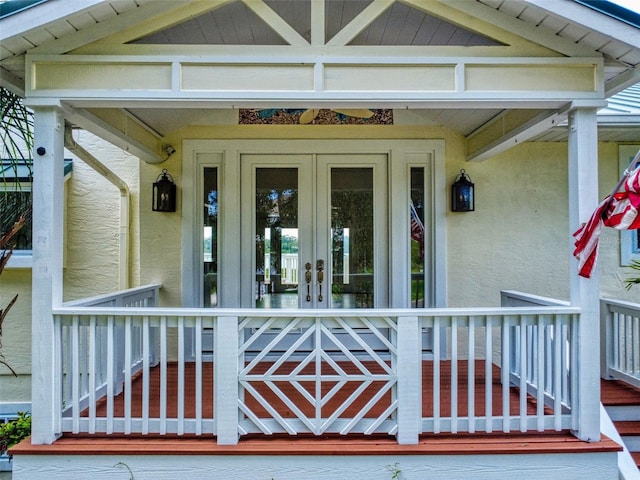 2950 Sunset Dr, New Smyrna Beach, FL 32168 - view of exterior entry featuring a porch, stucco siding, and french doors