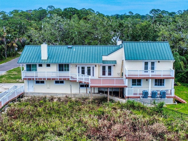 2950 Sunset Dr, New Smyrna Beach, FL 32168 - back of house featuring a chimney, french doors, metal roof, and a standing seam roof