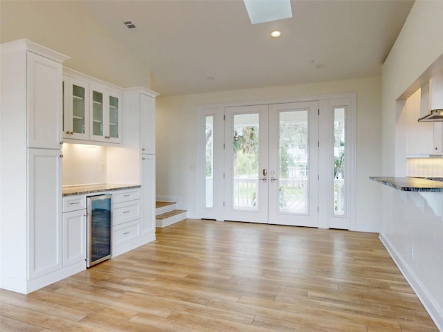 2950 Sunset Dr, New Smyrna Beach, FL 32168 - indoor dry bar featuring wine cooler, french doors, light wood-style flooring, vaulted ceiling, and recessed lighting