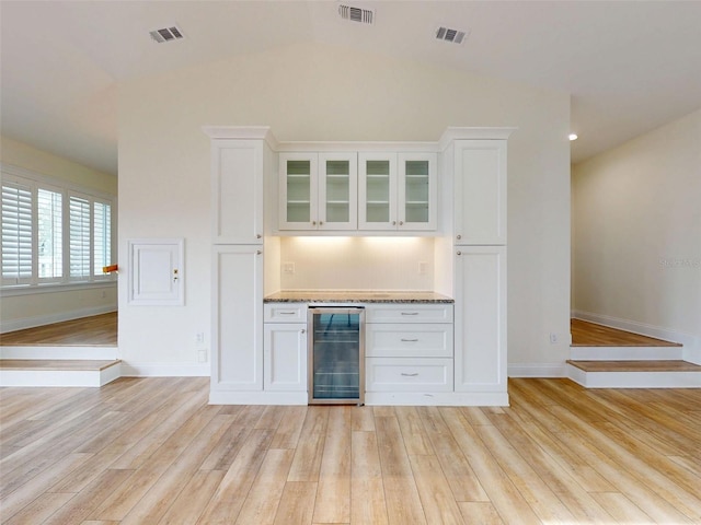 2950 Sunset Dr, New Smyrna Beach, FL 32168 - indoor dry bar featuring wine cooler, light wood-style flooring, baseboards, and vaulted ceiling