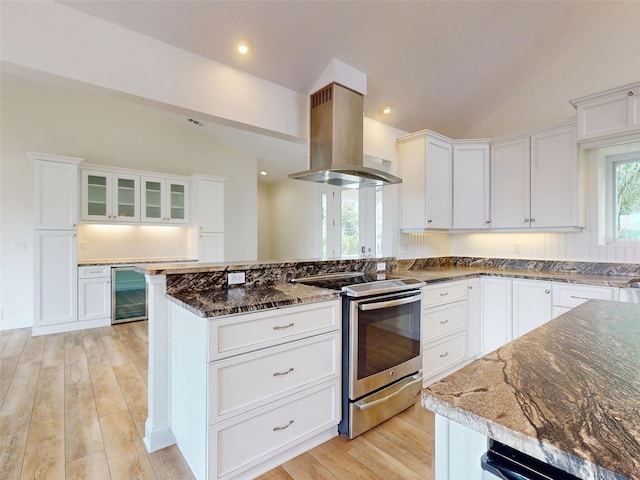 2950 Sunset Dr, New Smyrna Beach, FL 32168 - kitchen with island exhaust hood, beverage cooler, stainless steel range with electric cooktop, dark stone countertops, and lofted ceiling