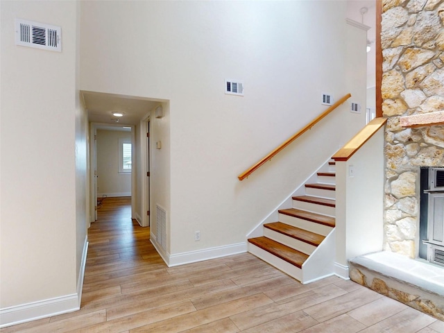 2950 Sunset Dr, New Smyrna Beach, FL 32168 - stairs with wood finished floors, a high ceiling, and baseboards