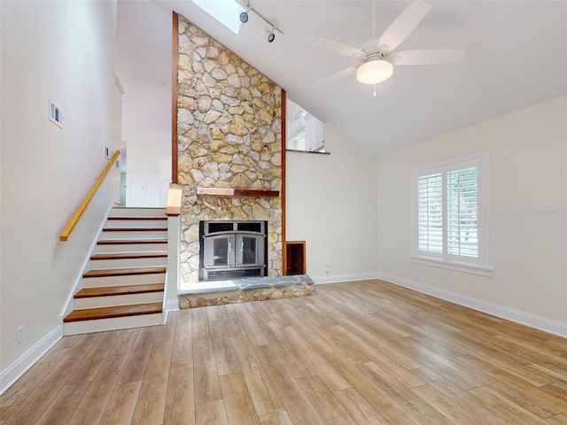 2950 Sunset Dr, New Smyrna Beach, FL 32168 - unfurnished living room with wood finished floors, a skylight, track lighting, ceiling fan, and high vaulted ceiling