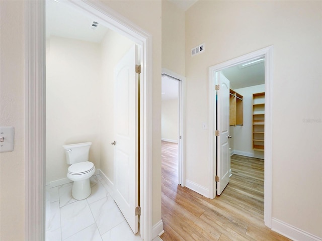 2950 Sunset Dr, New Smyrna Beach, FL 32168 - bathroom featuring toilet, wood finished floors, and baseboards