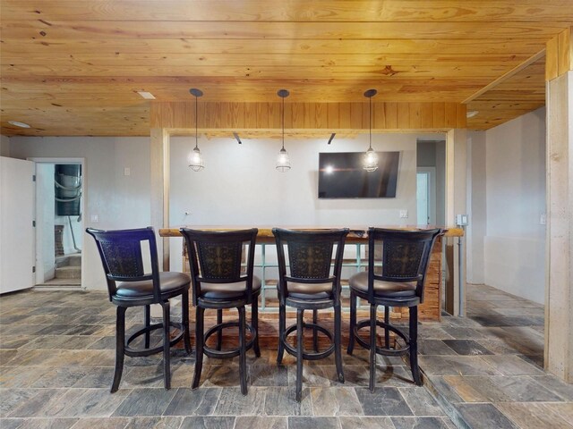 2950 Sunset Dr, New Smyrna Beach, FL 32168 - indoor dry bar with wood ceiling, stone finish flooring, and decorative light fixtures