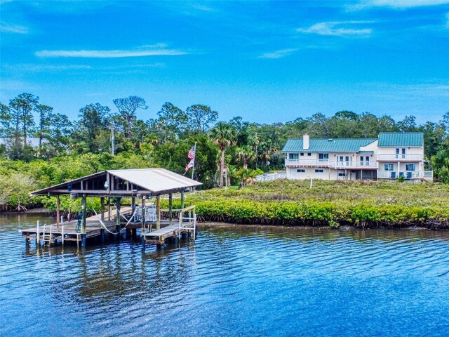 2950 Sunset Dr, New Smyrna Beach, FL 32168 - dock featuring a water view, boat lift, and view of scattered trees