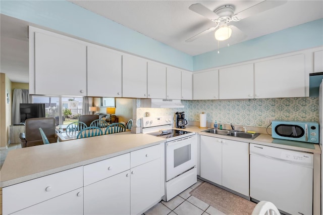 525 N Atlantic Ave Unit 39, New Smyrna Beach, FL 32169 - kitchen featuring white appliances, a sink, under cabinet range hood, a peninsula, and light countertops