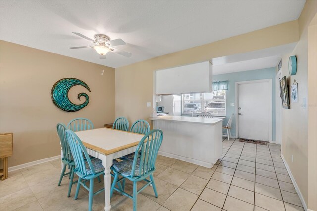525 N Atlantic Ave Unit 39, New Smyrna Beach, FL 32169 - dining room with a ceiling fan, light tile patterned flooring, and baseboards