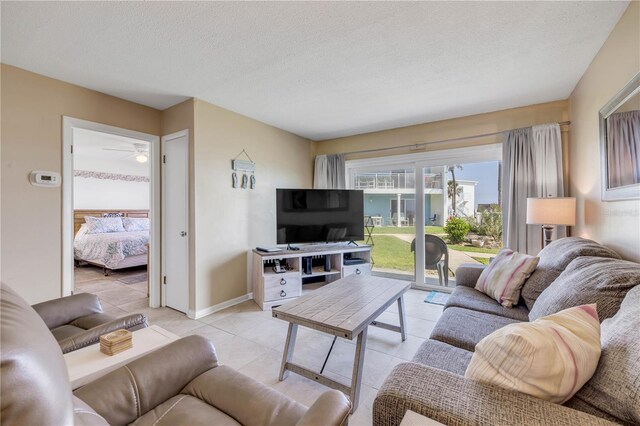 525 N Atlantic Ave Unit 39, New Smyrna Beach, FL 32169 - living room with light tile patterned flooring, a textured ceiling, and a ceiling fan