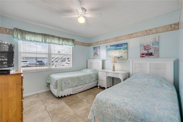 525 N Atlantic Ave Unit 39, New Smyrna Beach, FL 32169 - bedroom with ceiling fan, light tile patterned floors, and baseboards