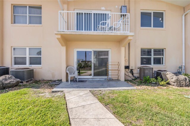 525 N Atlantic Ave Unit 39, New Smyrna Beach, FL 32169 - entrance to property with a balcony, central air condition unit, stucco siding, and a lawn