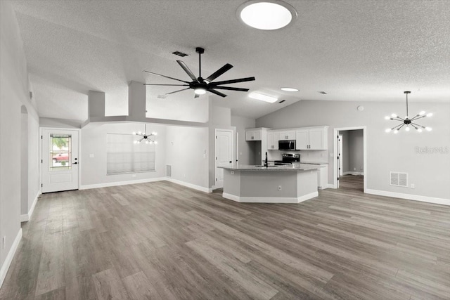 2325 Lime Tree Dr, Edgewater, FL 32141 - unfurnished living room with a chandelier, a textured ceiling, lofted ceiling, a sink, and light wood-type flooring