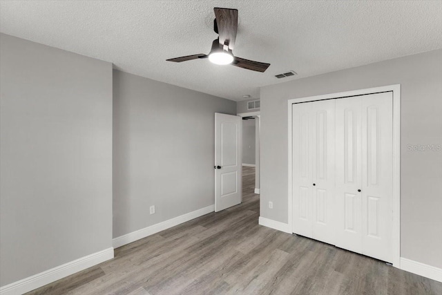 2325 Lime Tree Dr, Edgewater, FL 32141 - unfurnished bedroom featuring wood finished floors, a closet, a textured ceiling, baseboards, and a ceiling fan