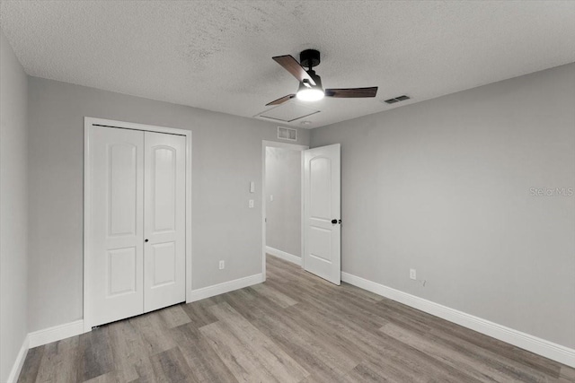 2325 Lime Tree Dr, Edgewater, FL 32141 - unfurnished bedroom with wood finished floors, a closet, a textured ceiling, and baseboards