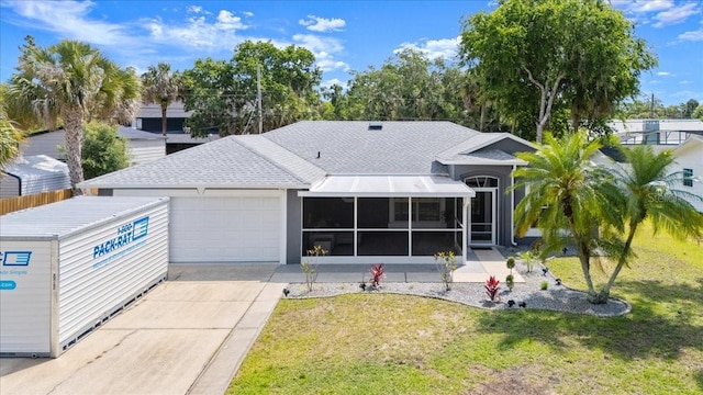 2325 Lime Tree Dr, Edgewater, FL 32141 - view of front facade featuring a garage, driveway, a sunroom, a front lawn, and a shingled roof