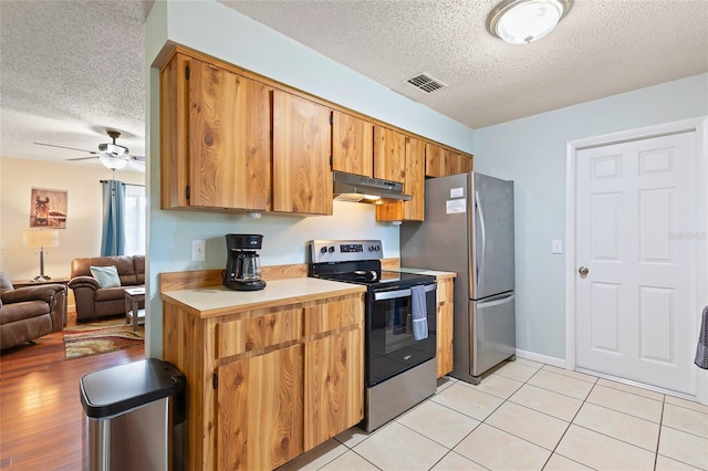 1723 Needle Palm Dr, Edgewater, FL 32132 - kitchen featuring stainless steel appliances, a textured ceiling, under cabinet range hood, open floor plan, and light countertops