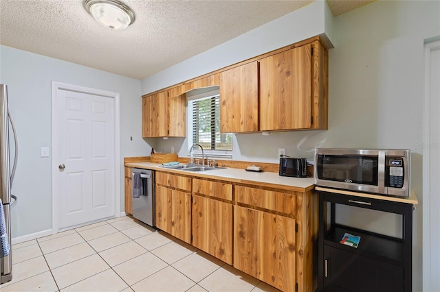 1723 Needle Palm Dr, Edgewater, FL 32132 - kitchen featuring stainless steel appliances, light countertops, a textured ceiling, light tile patterned floors, and brown cabinetry