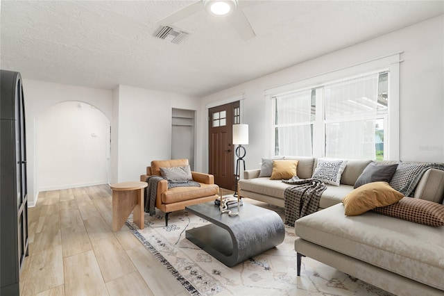 25 Dolphin Ave, Ormond Beach, FL 32176 - living area featuring arched walkways, healthy amount of natural light, a ceiling fan, light wood-style floors, and a textured ceiling