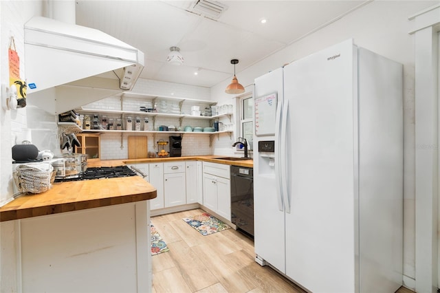 25 Dolphin Ave, Ormond Beach, FL 32176 - kitchen with wooden counters, white refrigerator with ice dispenser, decorative backsplash, dishwasher, and white cabinetry