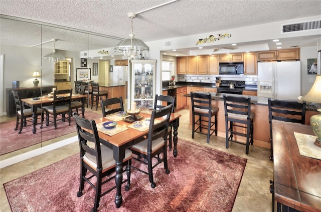 4435 S Atlantic Ave Unit 416, Port Orange, FL 32127 - dining area with a textured ceiling, light tile patterned floors, and a chandelier
