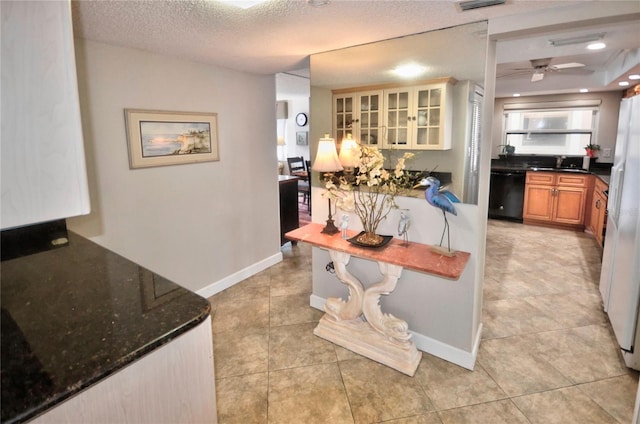 4435 S Atlantic Ave Unit 416, Port Orange, FL 32127 - kitchen featuring dishwasher, a sink, light tile patterned floors, dark stone counters, and brown cabinetry
