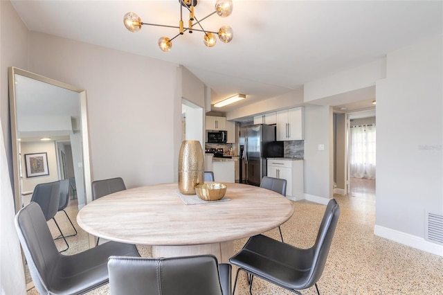 2900 S Peninsula Dr, Daytona Beach, FL 32118 - dining space with baseboards, dark aggregate flooring, and a chandelier