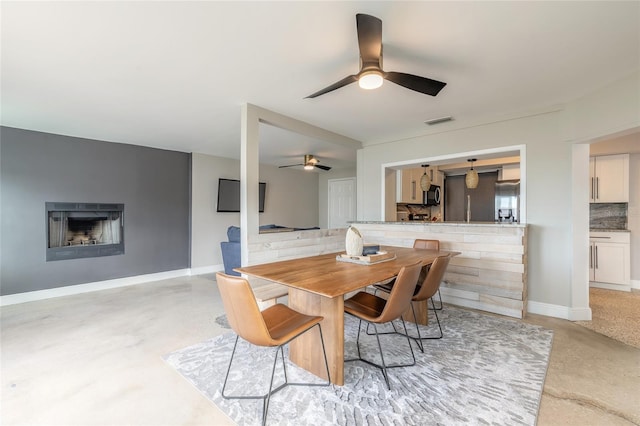 2900 S Peninsula Dr, Daytona Beach, FL 32118 - dining space featuring ceiling fan, a fireplace, and baseboards