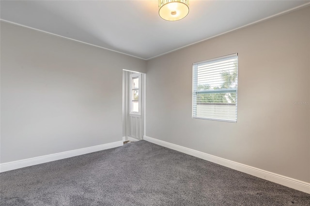 2900 S Peninsula Dr, Daytona Beach, FL 32118 - unfurnished room featuring dark colored carpet, crown molding, and baseboards