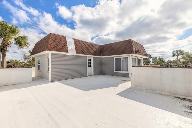 2900 S Peninsula Dr, Daytona Beach, FL 32118 - view of front of property featuring roof with shingles, mansard roof, and a patio area