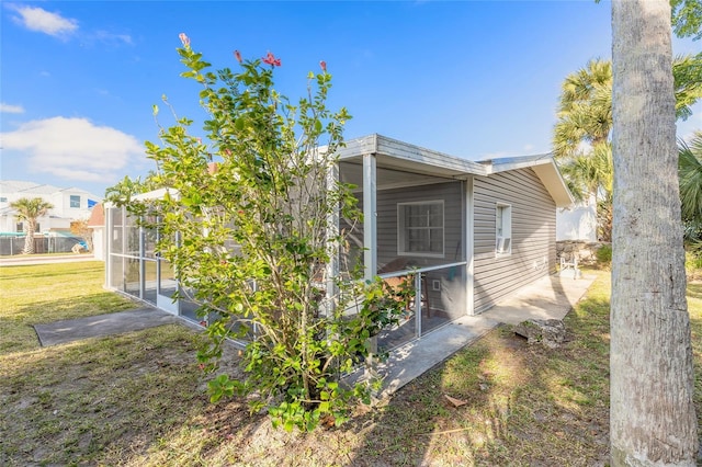 2900 S Peninsula Dr, Daytona Beach, FL 32118 - view of side of home with a sunroom and a yard