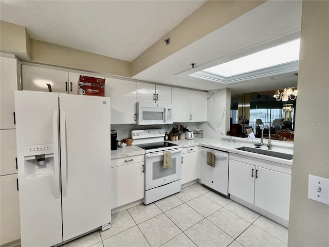 2700 N Peninsula Ave Unit 322, New Smyrna Beach, FL 32169 - kitchen with white appliances, a sink, a chandelier, light countertops, and white cabinets
