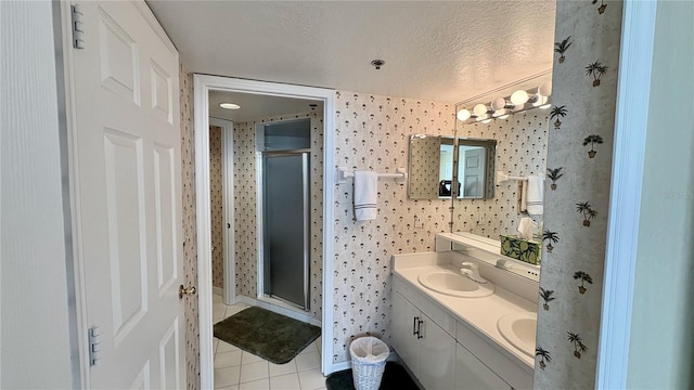 2700 N Peninsula Ave Unit 322, New Smyrna Beach, FL 32169 - full bath featuring tile patterned floors, double vanity, a stall shower, and a textured ceiling