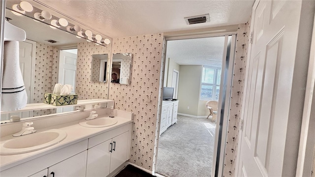 2700 N Peninsula Ave Unit 322, New Smyrna Beach, FL 32169 - full bathroom with wallpapered walls, double vanity, baseboards, and a textured ceiling