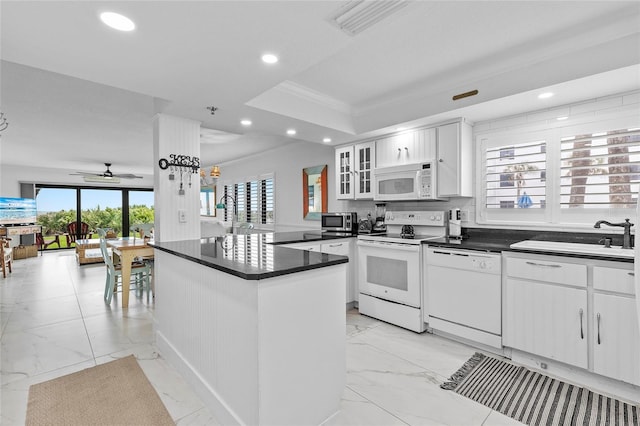 5301 S Atlantic Ave Unit 140, New Smyrna Beach, FL 32169 - kitchen with white appliances, light marble finish floors, recessed lighting, dark countertops, and plenty of natural light